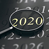 3D illustration of year 2020 written in golden letters and a magnifying glass over black background