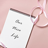 top view on notebook with article title - pink ribbon on table