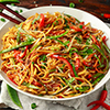 Chow mein, noodles and vegetables dish with wooden chopsticks