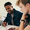 African boy studying with classmates. Group of multi-ethnic students working on college assignments 