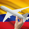 Airplane in hand with national flag on background - Colombia