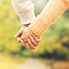 A picture of a couple holding hands in the park