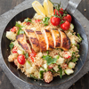 Couscous with grilled chicken breast in iron skillet