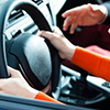 cropped image of hands on steering wheel - instructor guiding driver
