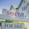 Sold sign in front of a house in a residential neighborhood