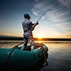 cropped image of fishing rod in front of water