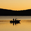 Silohuette of early morning fishing boat on a lake at dawn