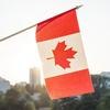 Flag of Canada from window on sunset background