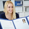 businesswoman in a job interview with a corporate personnel manager who is reading her CV in a blue 