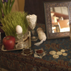 table with grass, frame, coins, fish bowl, egg, apple for norooz celebration