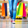 woman in mall holding shopping bags - cropped at legs