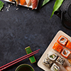 Set of sushi and maki roll and green tea over stone table. Top view with copy space