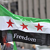 A protester waiving a Syrian flag during a protest rally organized to raise awareness and commemorat