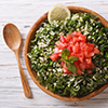 Tabbouleh salad in a wooden bowl on the table
