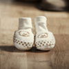focus of baby boots with parents feet visible behind