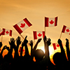silhouette of group of people holding canada flags