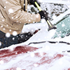 transportation, winter, weather, people and vehicle concept - closeup of man cleaning snow from car 