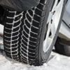 close up of car tires on snowy road