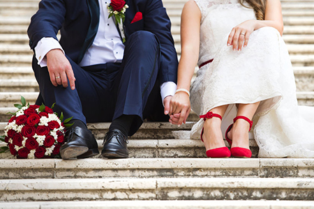 young wedding couple holding hands as they enjoy romantic moments outside on the stairs