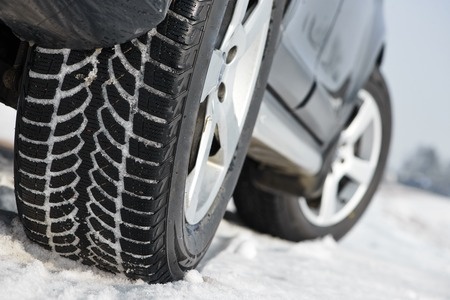 close up of car tires on snowy road