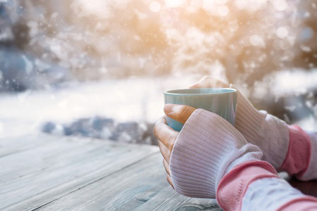 keeping warm with cup of hot drink in winter