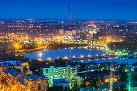 Night view of the city of Donetsk from a great height, a river in the center and a bridge over it