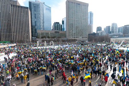 Toronto, Ontario, Canada â€“ February 27, 2022: Protestors with banners and Ukrainian flags in Downt