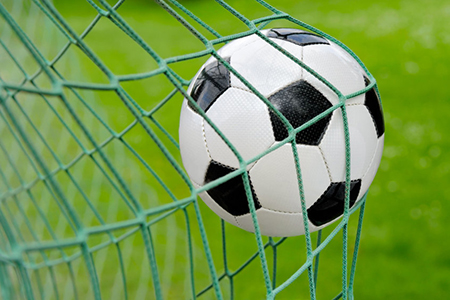 Close-up of a soccer ball flying into the net