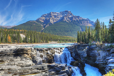 The Athabasca Falls with Rocky Mountain peak behind
