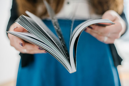 woman holding book, blurred background