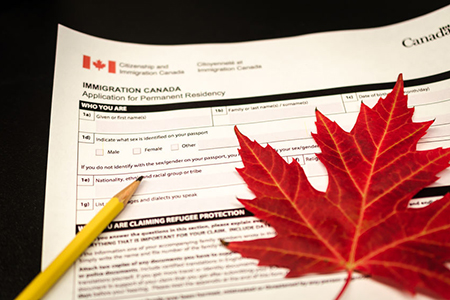 canada immigration form with pencil and maple leaf
