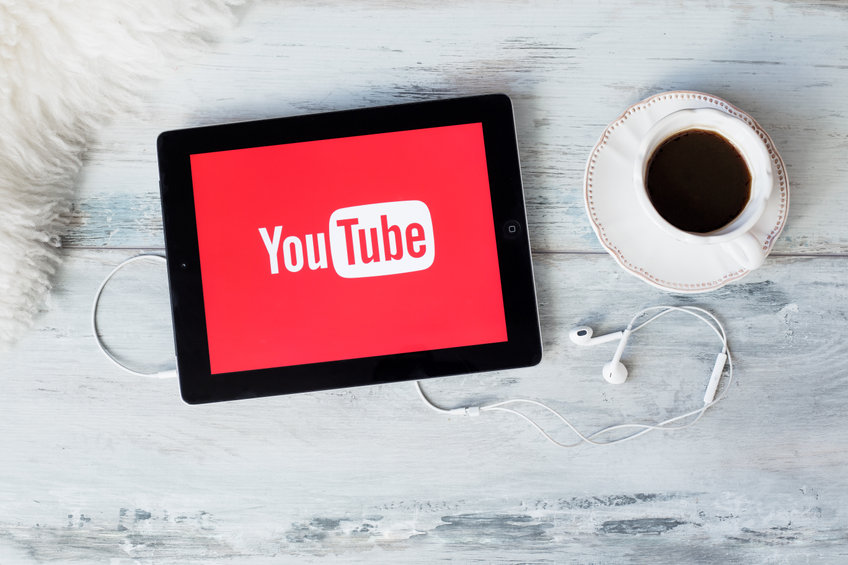red YouTube splash screen on tablet. Tablet and coffee on table