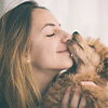 Young woman kissing her dog
