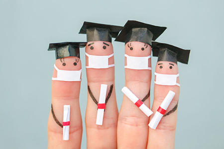 Fingers art of students in medical mask from COVID-2019. Graduates holding their diploma after gradu