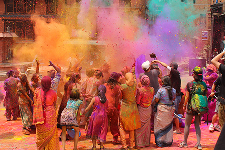 Group of people celebrating Holi - dusting of colours 