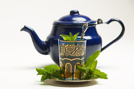 Traditional arab mint tea in a traditional cup with mint leaves