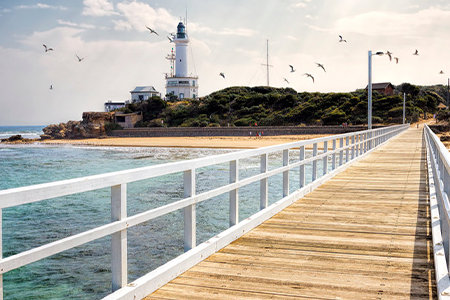 Clean beach with lighthouse in background