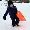 Young child with orange sled