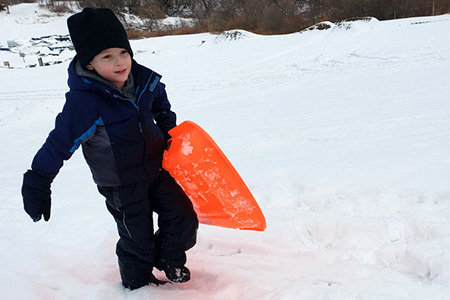 Young child with orange sled