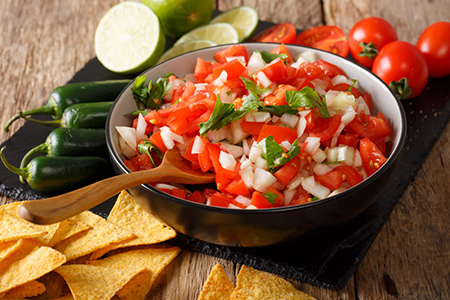 Mexican pico de gallo from tomatoes, onions, cilantro and jalapeno pepper close-up in a bowl and nac