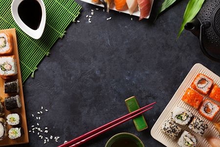 Set of sushi and maki roll and green tea over stone table. Top view with copy space