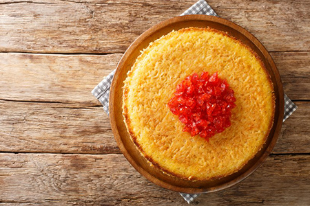 Iranian tahchin rice cake with chicken closeup in the plate on the table. horizontal top view from a