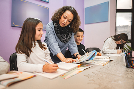 Female teacher helping elementary students