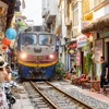 Train passing narrow road in old town in Hanoi, Vietnam.