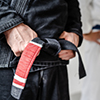 Side view of hand of unknown caucasian man in kimono gi standing while holding black bjj belt brazil