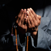 Close up of a Muslim mans hands praying and holding prayer beads