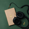 Book and headphones on dark green background,
