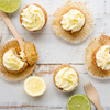 Lemon and poppy seed cupcakes with cheese cream frosting and lemon and lime zest on a rustic white w