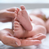 Mother and her newborn baby on bed, closeup. Space for text