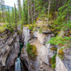 The Canadian Rockies. Cool cloudy day. Powerful waterfall in a picturesque gorge Maligne Canyon. Coo